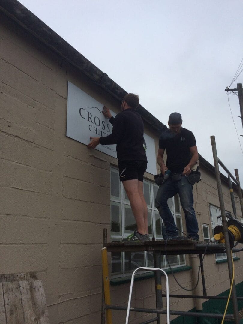 a man on a scaffolding next to a sign